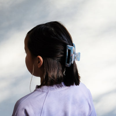 girl wearing blue acetate claw clip in hair