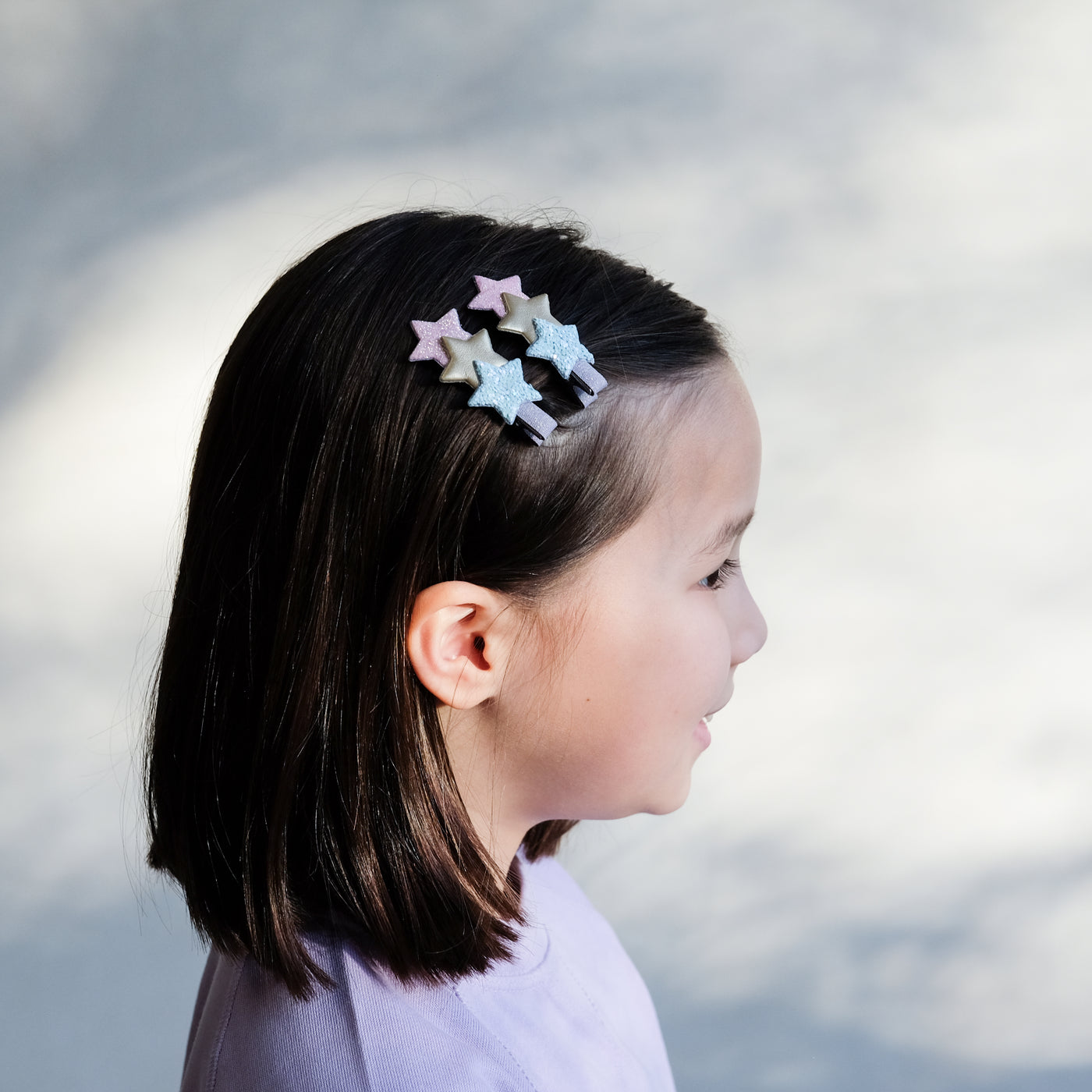 girl wearing star layered clips in pastel colours