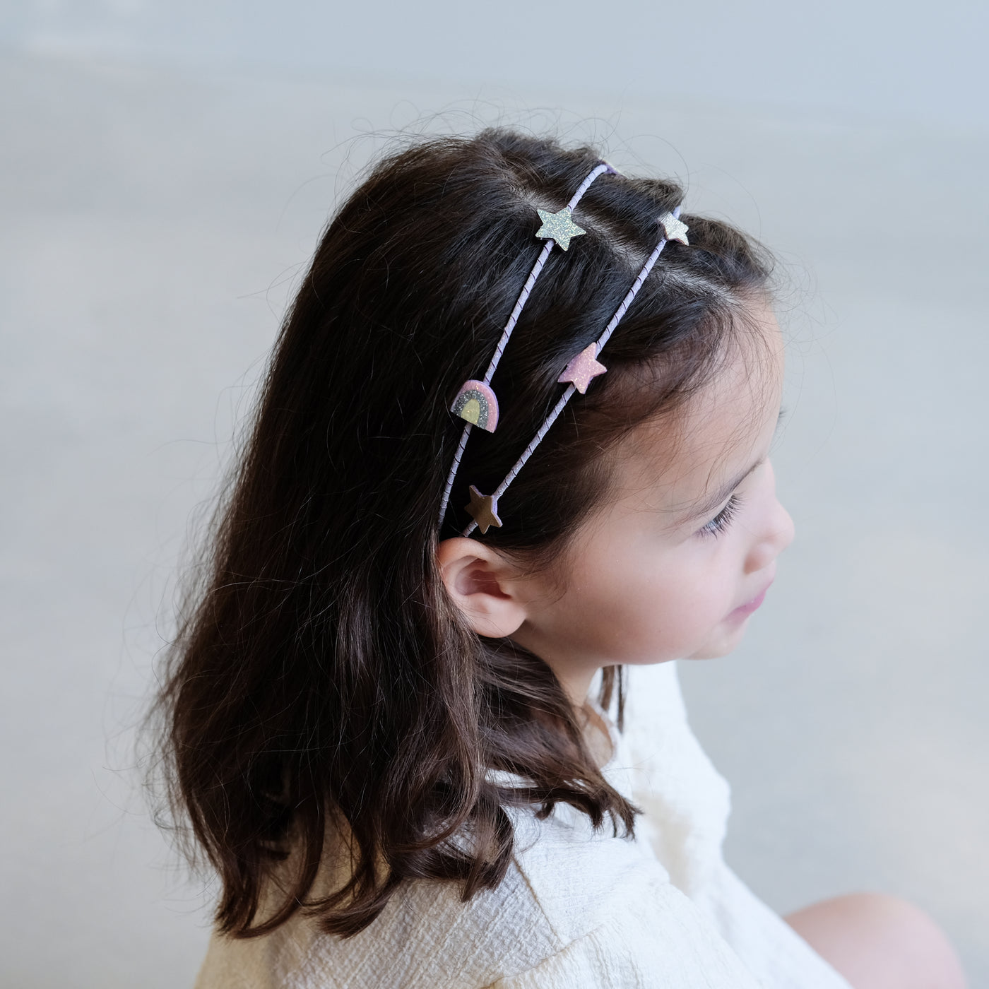 girl wearing rainbow and star double alice band in hair