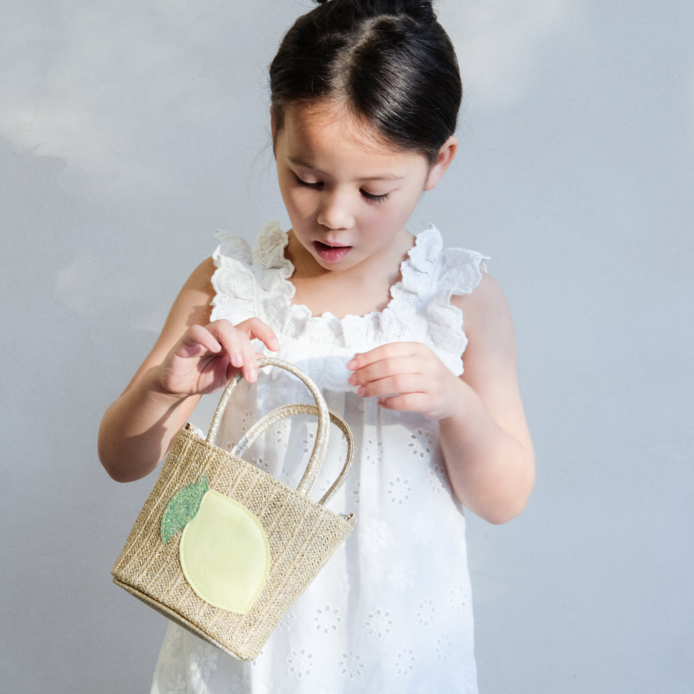 girl holding a lemon straw bag in her hand