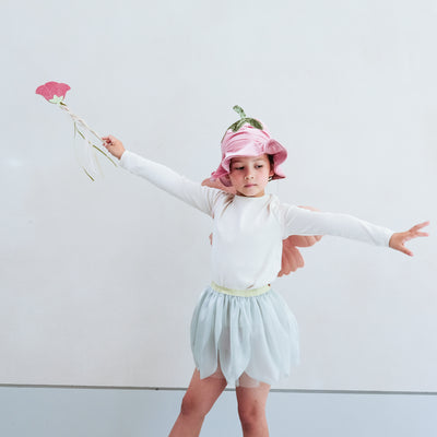Child wearing a full flower fairy dress up set including velvet wings, velvet hat with stalk, soft green tutu and flower wand with ribbon trails