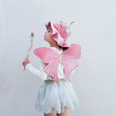 Child wearing a full flower fairy dress up set including velvet wings, velvet hat with stalk, soft green tutu and flower wand with ribbon trails