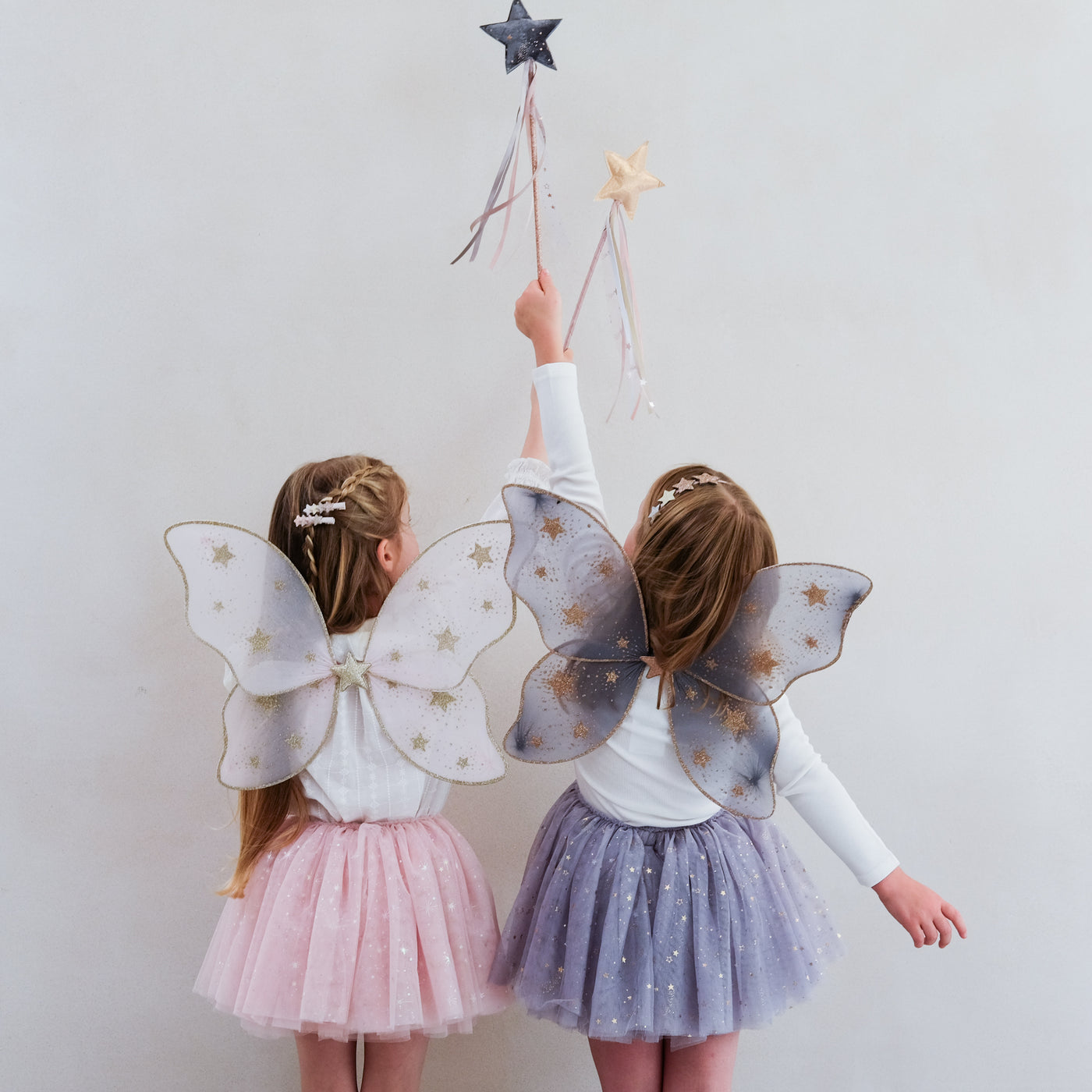 Video of two young girls wearing pink and grey fairy outfits