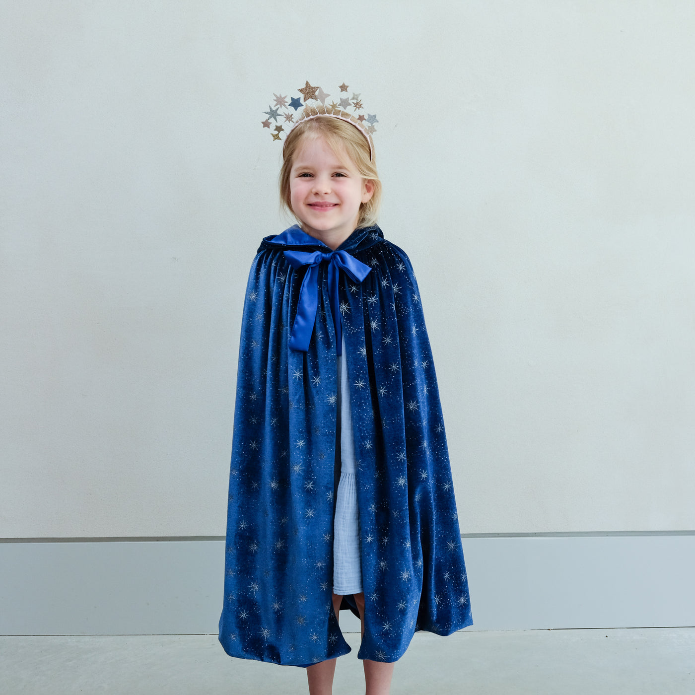 Video of young girl wearing a blue velvet cape with stars on it