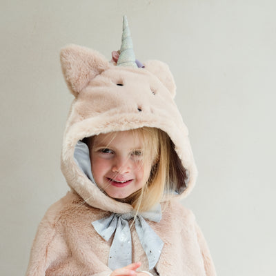 Video of a young girl wearing a fluffy novelty unicorn cape