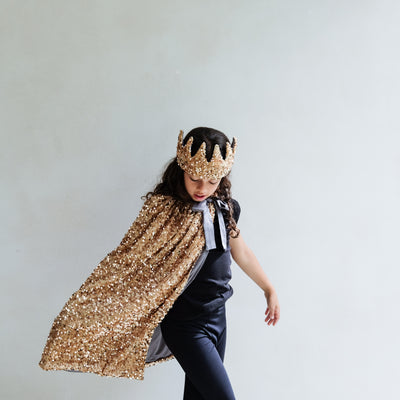 girl wearing gold sequin cape