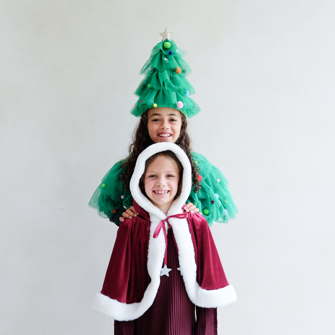 Video of two young girls wearing a christmas tress fancy dress outfit and another wearing a red velvet santa cape