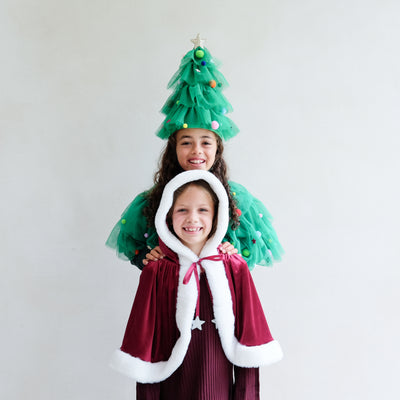 Video of two young girls wearing a christmas tress fancy dress outfit and another wearing a red velvet santa cape