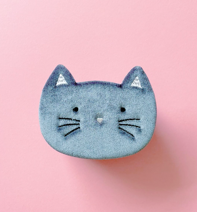 Kitty cat jewellery box with cat and mouse hair clips and accessories inside against a pink background